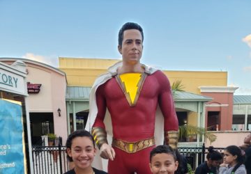 Kids in front of a Shazam statue