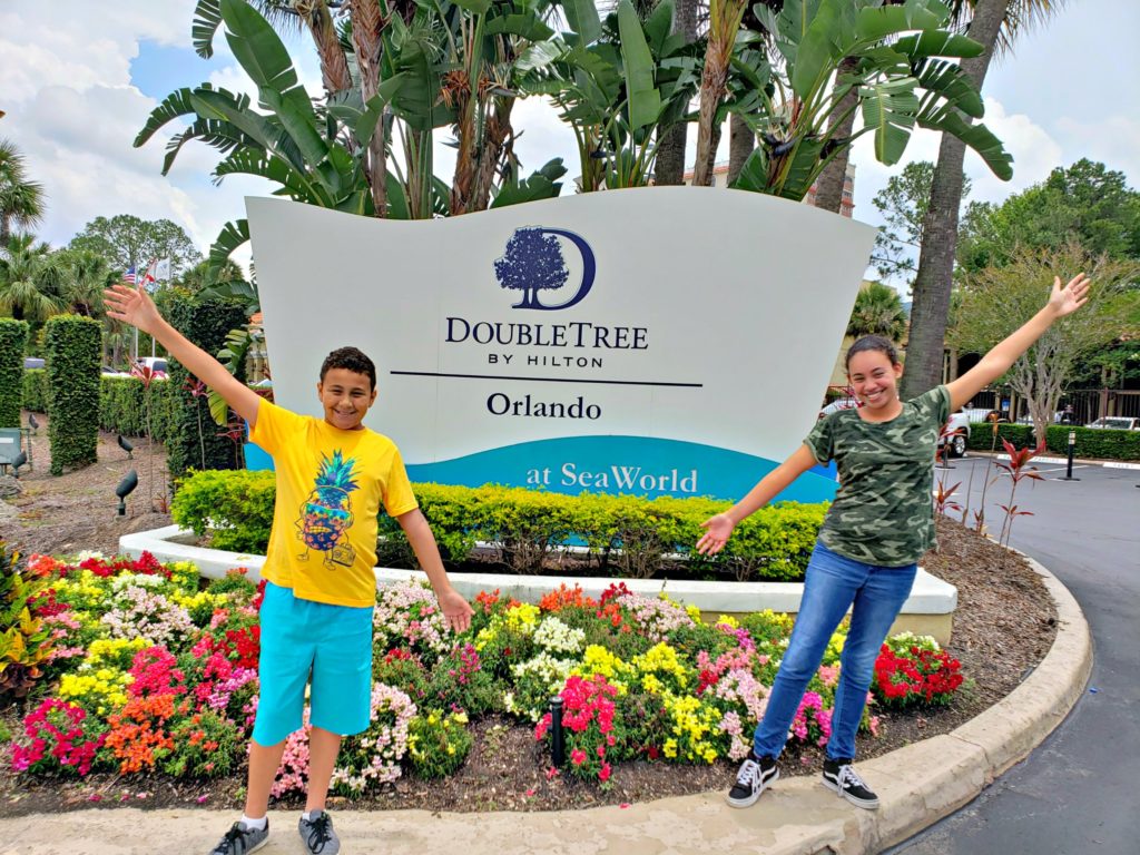 kids in front of a hotel entrance sign